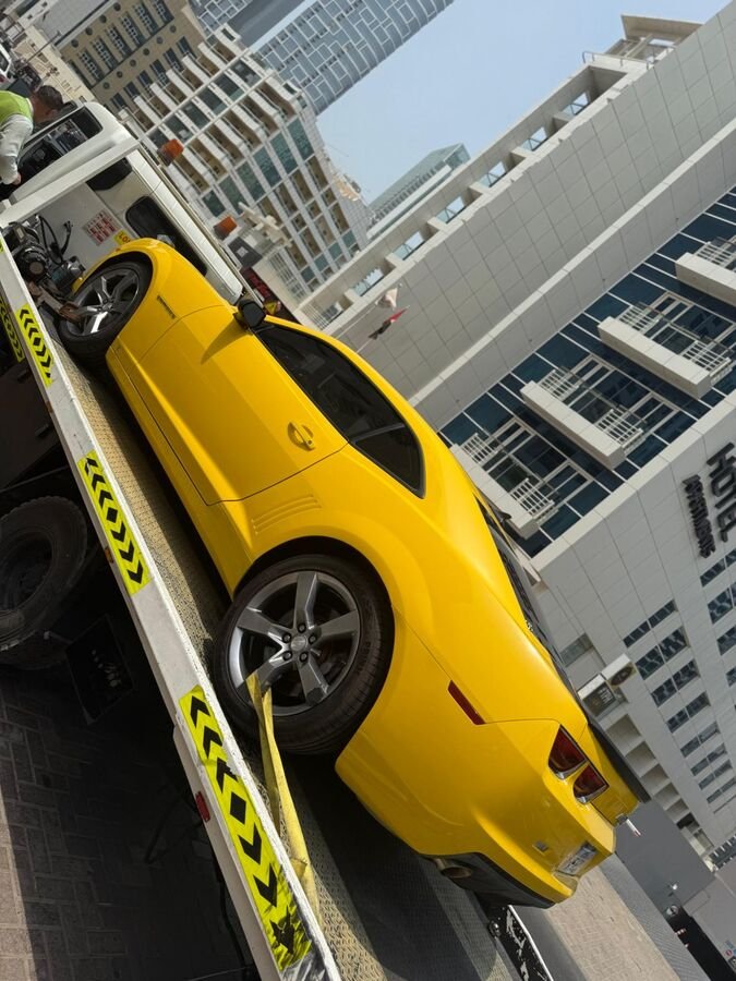 Yellow Camaro on recovery truck